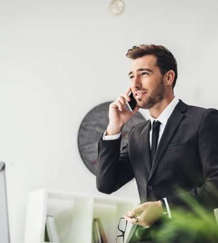 happy-young-businessman-talking-by-phone-in-office-2021-08-29-17-03-22-utc.jpg